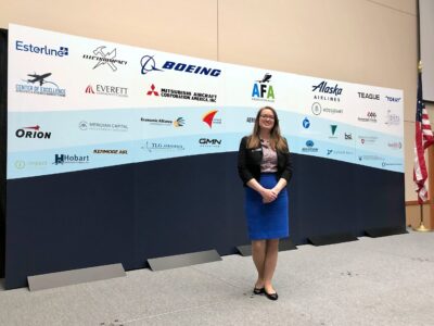 Brianna Karle in front of one of the backdrops she created for the Aerospace Futures Alliance Annual Aerospace Summit